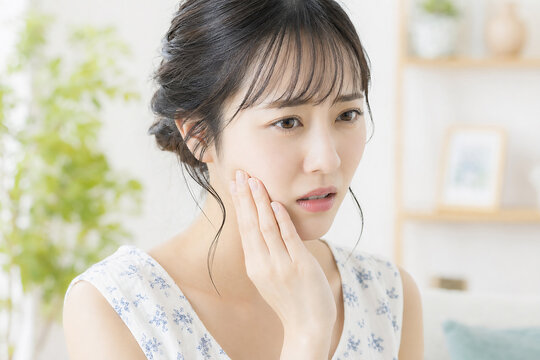 頬を押さえて歯痛に悩む若い日本人女性 虫歯 歯科 悩み 健康トラブル 室内 Generative AI
