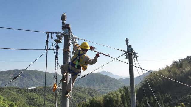 Electricity worker performing high-altitude maintenance on transmission line poles in mountainous area