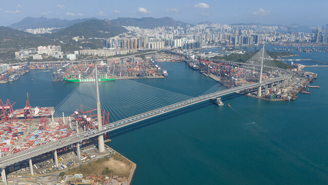 New Territories, Hong Kong - 15 February 2026: Aerial view of Stonecutters Bridge and Hong Kong International Terminals with container ships and cranes under a clear blue sky.