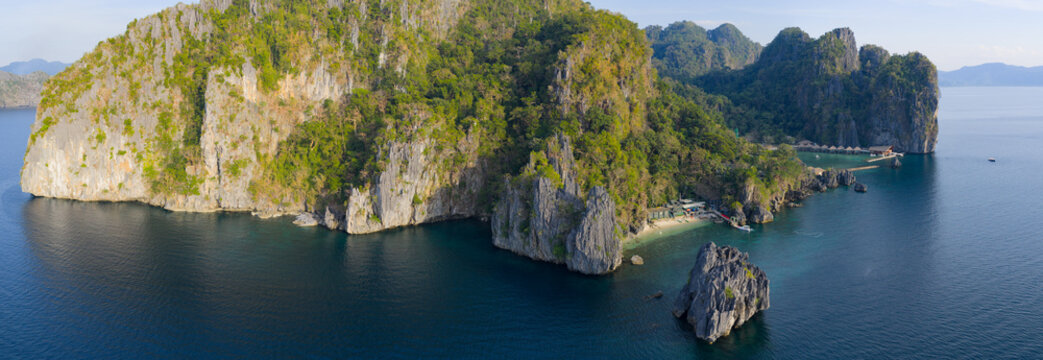 Lagen Island, a dramatic limestone island, rises in Bacuit Bay, El Nido. This area in the Philippines is a popular vacation destination due to its beautiful coral reefs, beaches, and hidden lagoons.