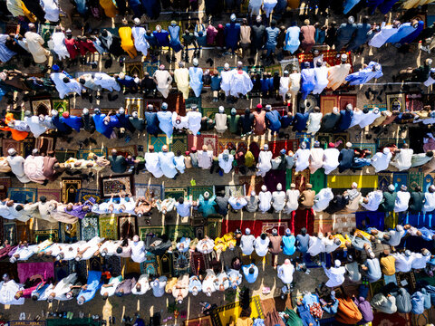 Zaria, Nigeria - 28 October 2025: Aerial view of a large crowd of people gathered for prayer at the Jum'at Mosque, Hayin Dogo Palladan, on a rocky landscape under bright sunlight.