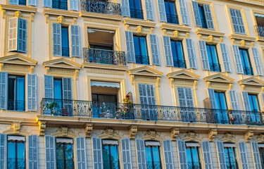 Fototapeta premium Close up of a yellow building with turquoise shutters, full frame, NIce, France
