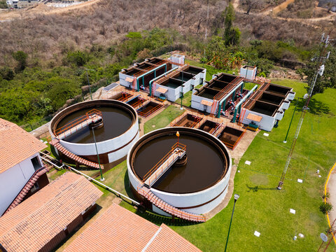 Aerial view of a water treatment plant featuring circular sedimentation tanks and rectangular filtration basins surrounded by lush green hills Puerto Vallarta, Jalisco, Mexico.