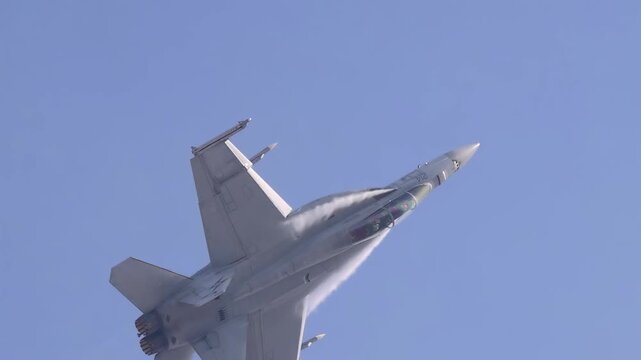 A captivating display of aerial prowess as a military jet executes evasive maneuvers and deploys flares against a clear blue sky.