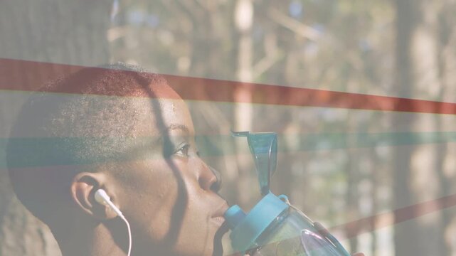Woman pausing run in park, flipping bottle spout and hydrating while overlay showing fitness
