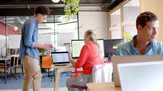 Standing man showing tablet walking to seated woman, causing animated business chart on monitors