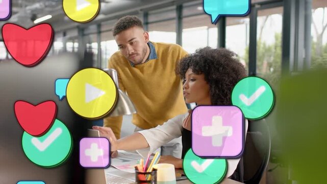 Woman clicking mouse, man leaning in, reviewing marketing while icons multiplying and drifting