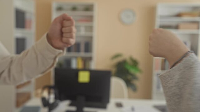 Man and woman hands performing handshake over office desk with computer, monitor and books in building; trust collaboration.