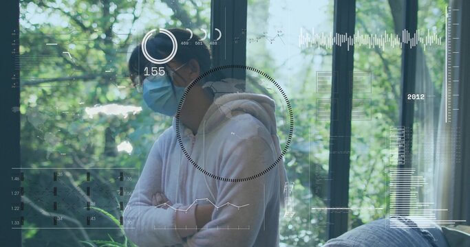 Standing Chinese girl wearing light hoodie, surgical mask, eyeglasses, looking near window with HUD