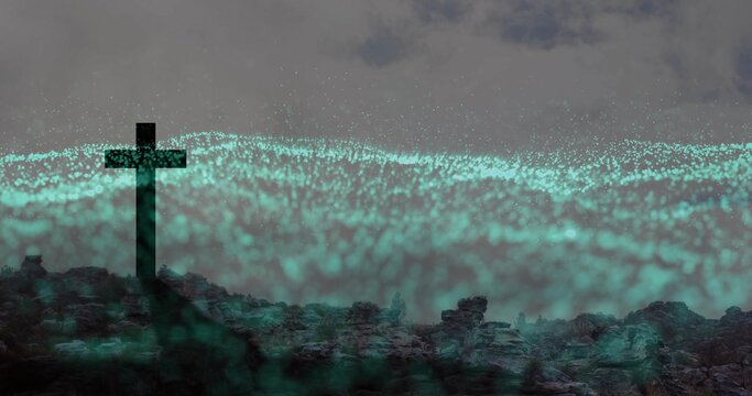 Standing dark cross silhouette anchoring jagged rocky ridge, with teal particle field, copy space