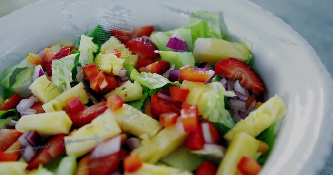 Showing white bowl with lettuce, pineapple, strawberries, cucumber, red onion, pepper on gray table