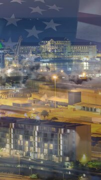 Vertical video: Frame changes starting flag overlay waving and fading over lit harbor evoking pride