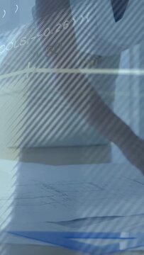 Vertical video: Woman reaching, aligning plans for design review with faint overlays crossing frame