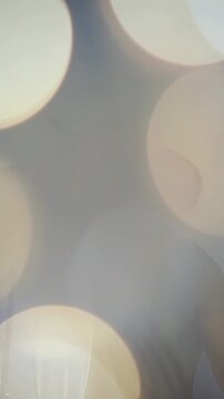 Vertical video: Singer holding mic, singing and causing bokeh to hide then reveal figure for music