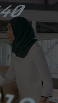 Vertical video: Woman scanning box, taping, shooting item for ecom while numerals overlaying frames