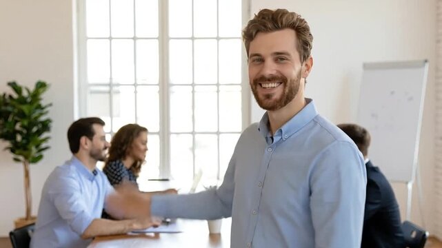 Male leader smiling with colleagues in bright modern office meeting