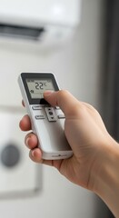 Fototapeta premium Hand Holding Air Conditioner Remote Control, Setting Temperature.