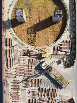 Aerial view of elevated highway construction site featuring concrete pillars, an excavator, and organized steel beams Taiwan.