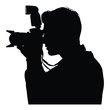 Silhouette of a professional photographer with a DSLR camera and flash unit capturing an image with focused concentration
