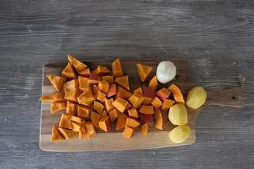 Three Peeled Potatoes and Diced Pumpkin Pieces on Cutting Board, Food Preparation Scene © jr-art