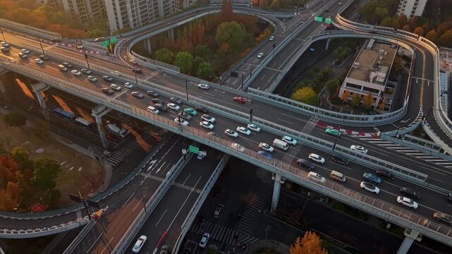 An aerial perspective shows vehicles moving across a multi-level road interchange during the morning