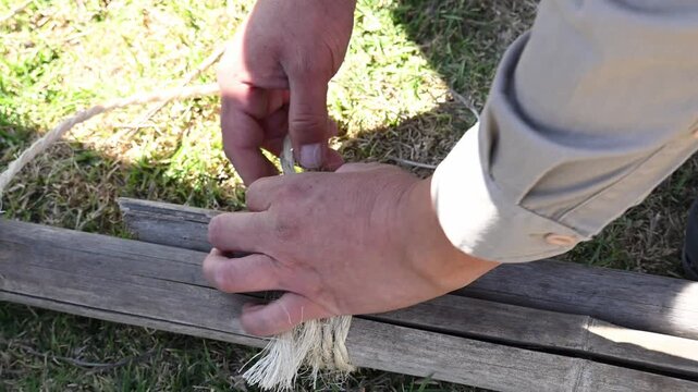 adult's hands tying a knot