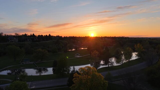 Drone aerial of Boise river park at sunset in Ann Morrison Park Idaho with walking paths
