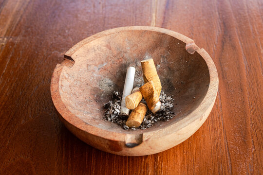 wooden ashtray with cigarette butts
