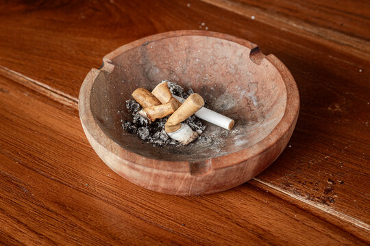 wooden ashtray with cigarette butts