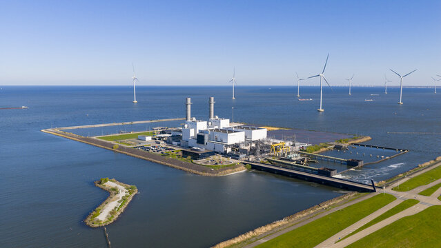 Aerial view of the ENGIE Maxima Power Plant on the IJsselmeer coast with offshore wind turbines and industrial chimneys in Lelystad, Flevoland, Netherlands.