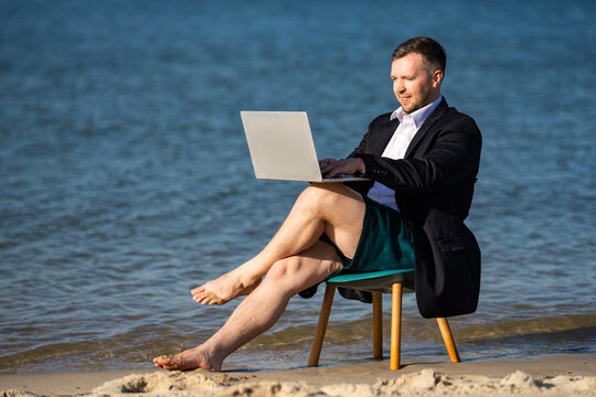 Vacation work with laptop outdoors. Businessman turns vacation into workation. Vacation lifestyle meets remote business. Beach chair supports vacation work.