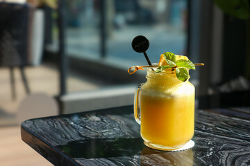 A jar of pineapple smoothie, garnished with fresh mint leaves and diced fruit. © Tantri