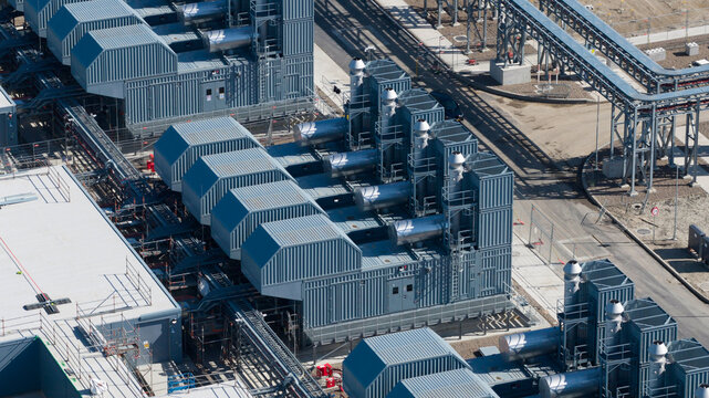 Aerial view of Datacenter Westpoort with industrial cooling units, metal containers, and complex piping systems in Groningen, Groningen, Netherlands.