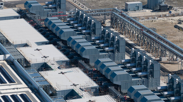 Aerial view of Datacenter Westpoort showing cooling systems, industrial pipes, and modern infrastructure under bright daylight in Groningen, Groningen, Netherlands.