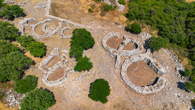 Aerial view of the Nuragic Sanctuary of Santa Vittoria, an ancient archaeological complex with stone ruins on the basaltic plateau of Serri, Sardinia, Italy