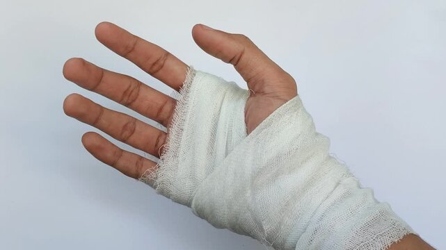 Hand wrapped in white medical bandage, first aid for injury, wound care and health recovery concept
