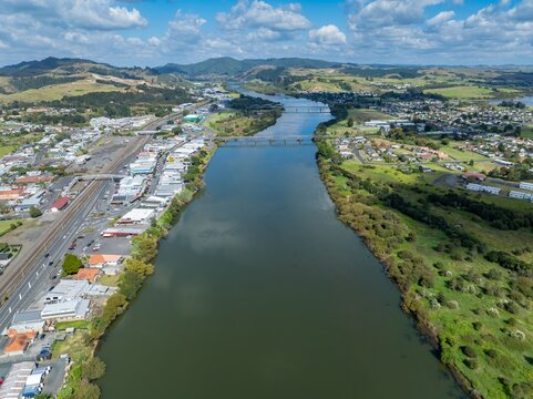 Aerial view of the Waikato River flowing through Huntly, New Zealand. The river is a vital resource for the community, providing water and recreation.