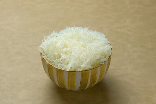 Fresh rice vermicelli noodles, rice noodles, rice sticks, mihun,  bihun, bee hoon or bihon served in a ceramic bowl. Perfect for Asian cuisine, healthy meal prep, and culinary backgrounds.