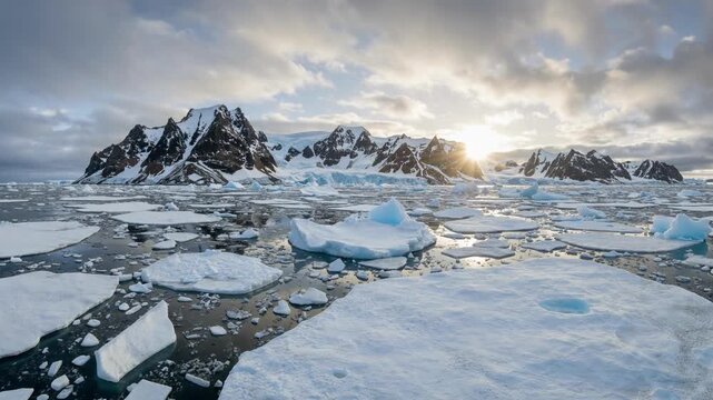 Glacial Ice Floes Floating on Dark Water under Dramatic Cloudy Sky in Arctic Landscape