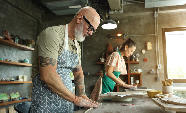 A happy couple makes ceramic plates in a workshop