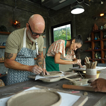 A happy couple makes ceramic plates in a workshop
