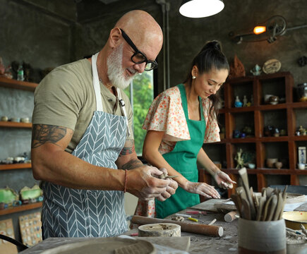 A happy couple makes ceramic plates in a workshop