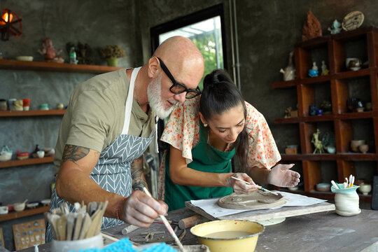 A happy couple makes ceramic plates in a workshop
