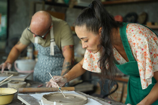 A happy couple makes ceramic plates in a workshop