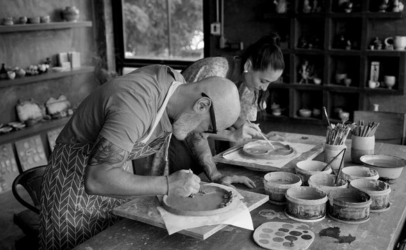 A happy couple makes ceramic plates in a workshop