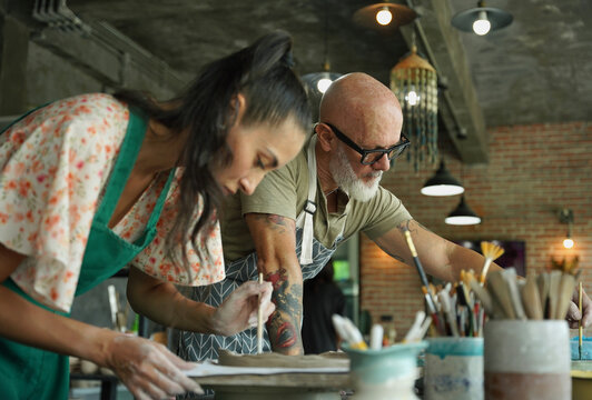 A happy couple makes ceramic plates in a workshop