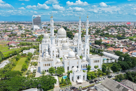 Aerial view of Sheikh Zayed Grand Mosque Solo Surakarta with its white domes and minarets under a blue sky in Kecamatan Banjarsari, Jawa Tengah, Indonesia.