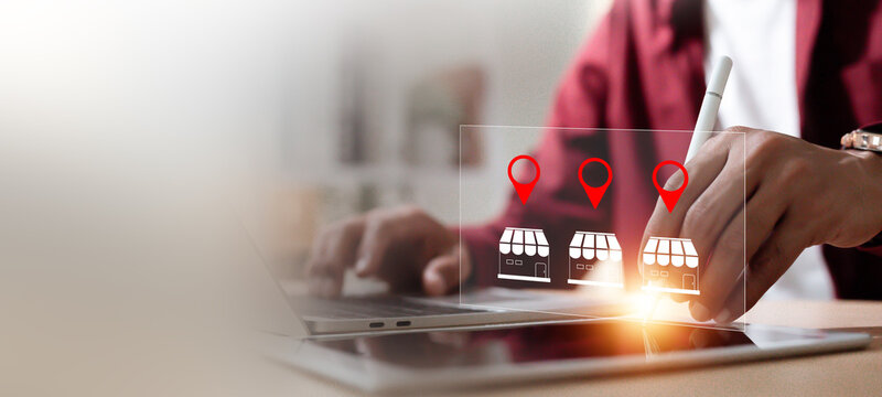 Small business store finding and location based service concept with businessman touching virtual shop icons on tablet.