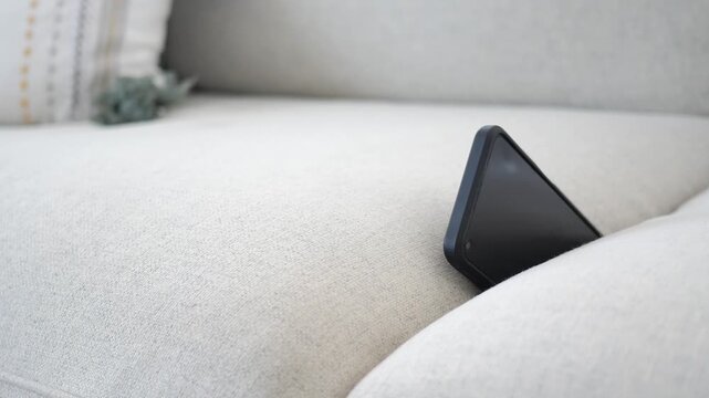 Lost Smartphone Hidden Between Sofa Cushions On A Light Beige Couch In A Cozy Living Room