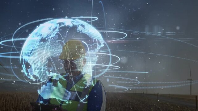 Engineer raising device and activating globe orbital rings over chest monitoring wind farm output